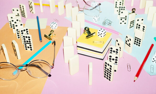 Curvy playful tactic row of dominos in office desk and hard flashlight