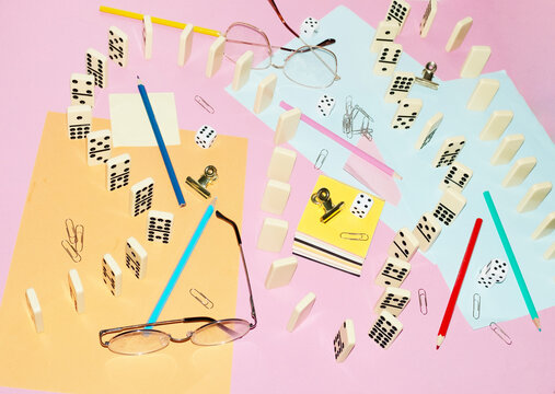 Curvy playful tactic row of dominos in office desk and hard flashlight