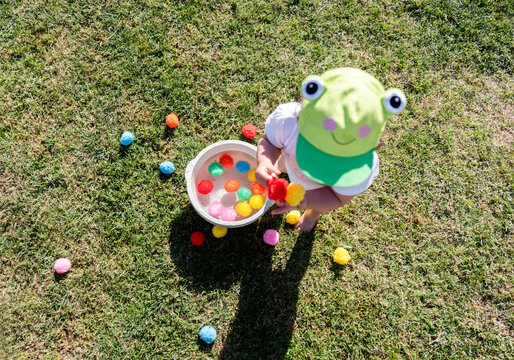 Child in costume playing with colorful water balloons