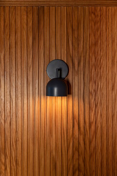 Vertical Oak Wood Paneling Wall with sconse light
