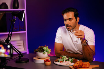 Healthy influencer in host channel presenting fresh vegetables in special dish of salad with brest...