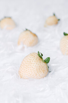 white strawberries on a white furry fabric