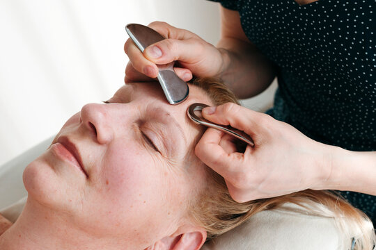 Woman Receiving Gua Sha Facial Treatment