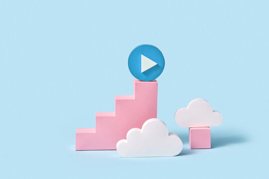 Handcraft paper staircase with blue button play on top among clouds