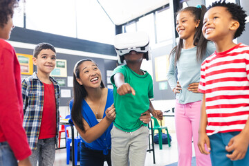 A biracial teacher guiding group of diverse students using VR headset - Powered by Adobe