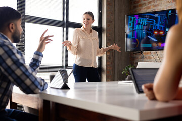 Asian businesswoman presenting to diverse team in a modern office
