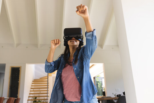 Young biracial woman enjoying virtual reality experience with VR headset