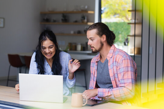 Young diverse couple are looking at a laptop together - Powered by Adobe
