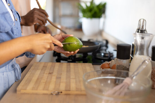 A young diverse couple are preparing breakfast with avocados in kitchen