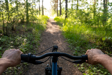 Man riding a bike. holding bike handlebar with one hand . Summertime outdoor leisure sport activity.