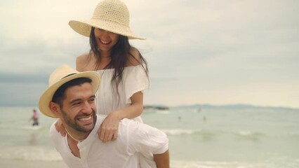 4K Happy Caucasian couple enjoy and fun outdoor lifestyle travel nature at the sea on summer beach holiday vacation. Man and woman walking and playing together at tropical island beach at sunset. 