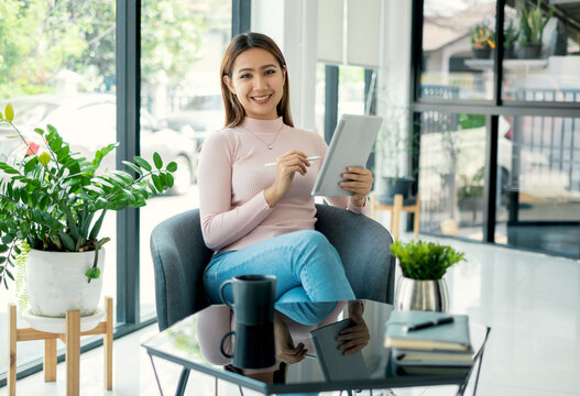 Female CEO in casual wear smiling and using tablet working Shown on the digital screen analyze and calculate the planning strategy for modern business