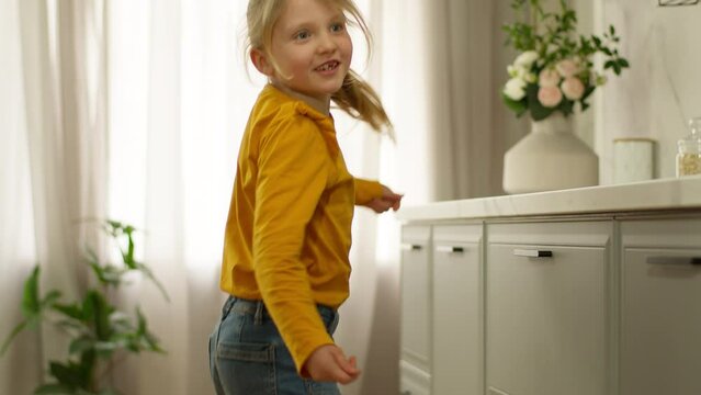 Little happy girl dancing singing daughter child joyful fun kid enjoyment celebrate weekend smile playful excited motion practicing jump energetic expression emotion positive active baby home morning