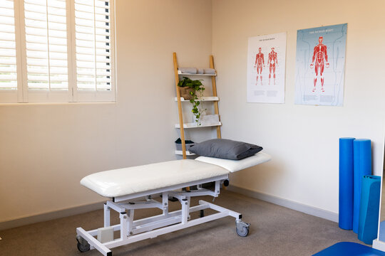 Empty prosthetic lab with white examination table and anatomical posters on wall