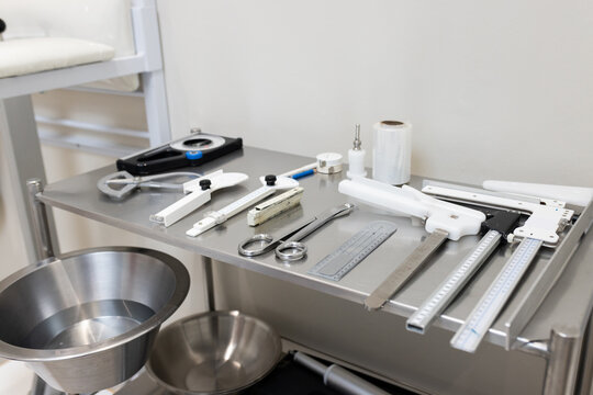 A variety of precision tools and instruments are neatly arranged on metal table