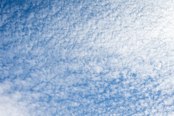 Beautiful blue sky with high Cirrocumulus white clouds, textured nature background
