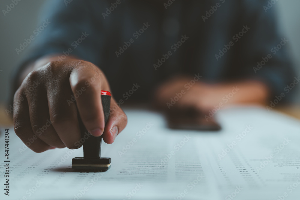 Poster closed up businessman hand using wooden stamping to document approve and reject document or project 