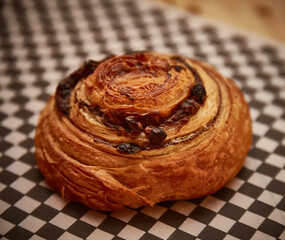 HANDMADE CINNAMON ROLL ON CHECKED PAPER