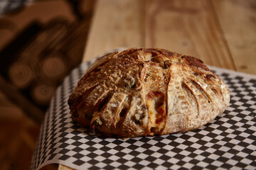 ARTISAN BREAD WITH CHEESE AND OLIVES ON WOODEN TABLE