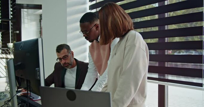 A different aged team in the modern office engages in discussions on business planning, market analysis and teamwork, united in their mission to achieve growth and boost profits through collaboration.