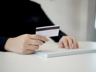 Young woman holding a credit card and laptop to shoping online