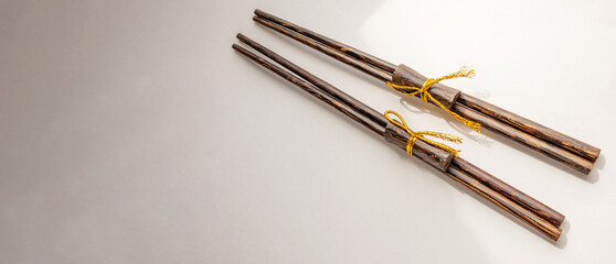 Two pairs of traditional bamboo sushi sticks, a banner with a place for text on the left