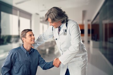 Fototapeta premium Happy young man talking with doctor in hospital