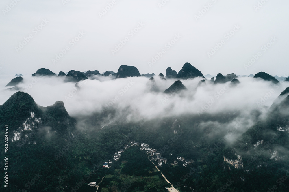 Wall mural Idyllic landscape of mountain village shrouded in mist