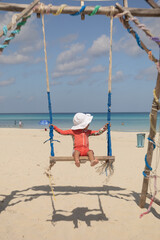 beautiful 2 years mexican litter girl on a swing , enjoy happy, travel concept