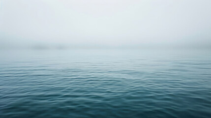 Calm body of water with a foggy sky in the background
