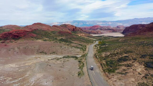 Aerial Shot Travelers with a Massive Expedition Truck Desert Landscape in Argentina Dusty Track Mountain in the Background