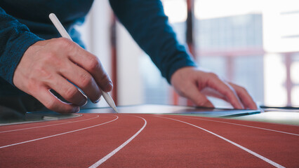 digital technology and business start up concept, businessman using pen and digital tablet working in modern office with running track background multi exposure
