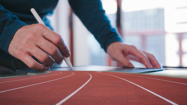 digital technology and business start up concept, businessman using pen and digital tablet working in modern office with running track background multi exposure