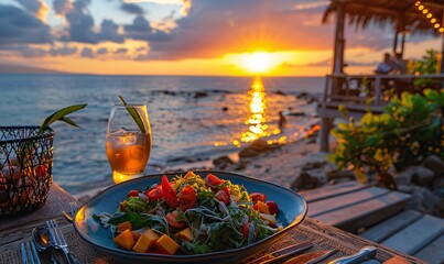 Obraz premium an idyllic dining scene with a deep blue plate of salad at a beachside bar, with the ocean and a beautiful sunset in the distance