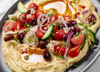 Greek hummus with veggies, olives, feta on plate