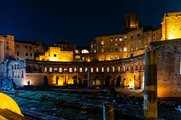 Obraz premium Rome, Italy - April 09, 2024: Night view of the ruins of the Roman Forum in Rome with tourists crowding its surroundings in Rome, Italy