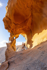 Adventurous Hikers Exploring Arco De Las Penitas in Golden Afternoon Light