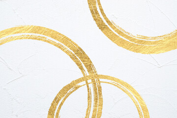 金色のブラシのストローク、背景は動きのある白塗りの壁面（アブストラクト）