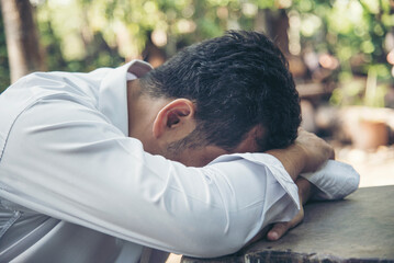 Obraz premium Failure businessman stress bankruptcy man sitting wood desk feeling nagative depression have headache. Men unemployed jobless recession crisis stress lost job. Despair Failure businesspeople concept