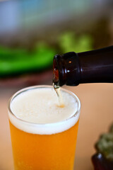 グラスにビールを注いでいる様子