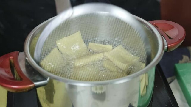 Italian chef cooks Panella Sicilian fritters made of chickpea flour closeup kitchen shot