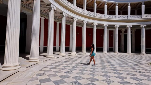 Beautiful young woman in a classic, Greek atrium with marble columns