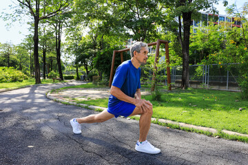 Senior Asian man is stretching his leg muscle during warm up exercise work out in the morning at public park for healthy and longevity
