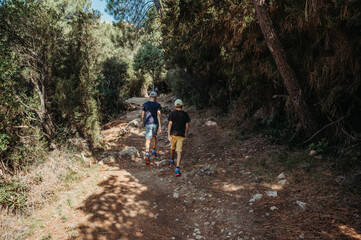 Fototapeta premium Two boys hiking in Corsica's rugged mountains with forest