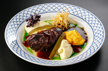 grilled beef tenderloin on a plate with side dish and sauce