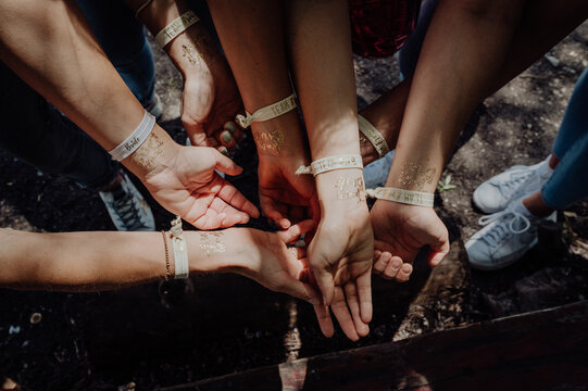 Women's arms with matching wristbands at a bachelorette party
