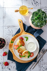 cottage cheese pancakes on a plate with strawberries and sauce.
