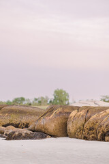 Weathered rocks on the sandy shore at Wingaersheek Beach during sunset