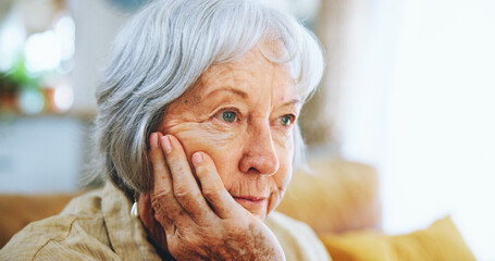 Thinking, home and senior woman on sofa for depression, nostalgia and reflection in living room....