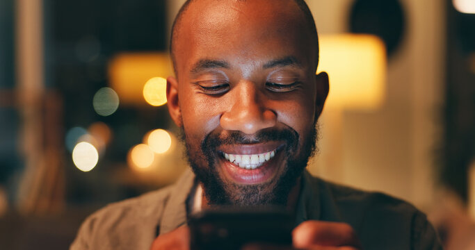 Phone, night and black man on social media to relax reading online research or entertainment on blog website. Smile, face or happy African person on mobile app for news or funny internet meme in home